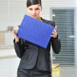 A portrait of a young business woman in an office with documents