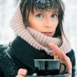 Portrait of young beautiful woman standing alone in winter park 