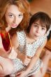 Mother and her daughter sitting together near christmas tree