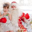 Christmas theme: Santa Claus and little girl having a fun. Indoo