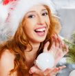 Christmas woman near a Christmas tree holding Christmas toy whil