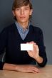Portrait of young handsome business man holding blank white busi