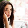 Portrait of young pretty woman talking with someone using cell p