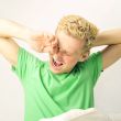 Young cheerful european man in his bed stretching for waking up.