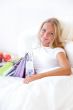 Young happy attractive girl unpack shopping bags in bedroom or h