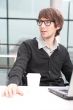 Friendly executive sitting in front of laptop