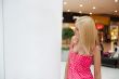 Beautiful shopping woman standing near informational stand insid