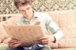 Closeup portrait of young man with newspaper 