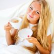 Young woman at home sipping tea or coffee from a cup