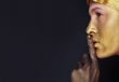 Portrait of young dancing girl with golden body art 