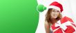 Young happy girl in Christmas hat. Standing indoors and holding 