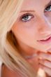 Portrait of pretty young woman standing outdoors near white wall
