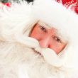 Portrait of Santa Claus standing outdoors. Snow falls. Natural l