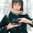 Portrait of young beautiful woman standing alone in winter park 