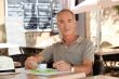 Man drinking coffee outside a cafe