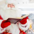 Santa sitting at home and reading a book. Indoors