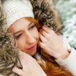 Portrait of pretty girl at winter background wearing warm clothe