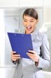 A portrait of a young business woman in an office with documents