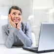 Young business woman on a laptop at her office. Daydreaming