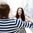 Young man meeting his girlfriend with opened arms at airport arr