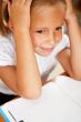 Image of smart child reading interesting book in classroom