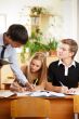 Teacher helping students in school classroom. Horizontally frame