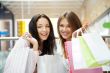 Two excited shopping woman together inside shopping mall. Horizo