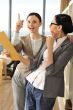Portrait of two businesswomen analyzing a report.