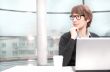 Friendly executive sitting in front of laptop