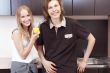 Playful young couple in their kitchen.