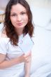 Happy woman reading a letter in her bedroom. She recieved a lett