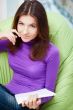 Young adult woman writing in her copybook while sitting"lim