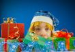 Surprised teen girl looking from behind the Christmas presents