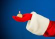 Santa`s hand holding a burning candle
