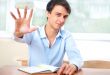 Businessman sitting indoors and writing plan in his diary