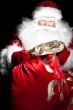 Santa sitting at the Christmas room and looking into the sack