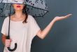 Young fashionable woman holding umbrella stan
