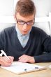 High school - Young male student write notes in classroom