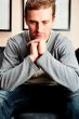 Closeup portrait of young man sitting on sofa 