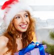 Christmas woman near a Christmas tree holding big gift box while