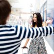 Young man meeting his girlfriend with opened arms at airport arr