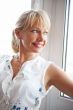 Closeup portrait of smiling woman standing near big window