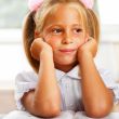 Image of smart child reading interesting book in classroom