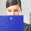 A portrait of a young business woman in an office with documents