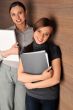 Portrait of two young handsome women standing relaxed against mo