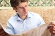 Closeup portrait of young man with newspaper 