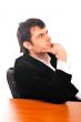 Portrait of a happy young businessman in suit sitting at office 