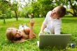 College students using laptop on campus lawn