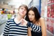 Portrait of young couple standing together at airport hall and l