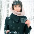 Portrait of young beautiful woman standing alone in winter park 